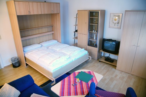 Wohnzimmer mit ausgeklapptem Schrankbett Wohnzimmer mit ausgeklapptem Schrankbett